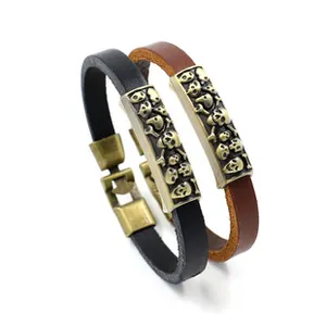Détail de bracelets vintage en cuir avec breloques tête de mort en noir et marron