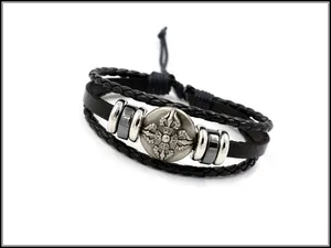 Detail eines mehrlagigen Lederarmbands mit silbernem Vajra-Emblem und Kordelzugverschluss