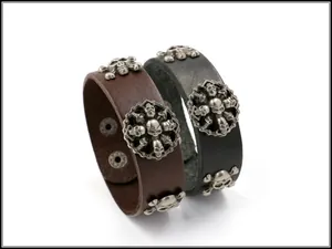 Détails de bracelets punk en cuir avec des charms tête de mort et des boutons pressions