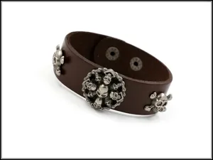 Vue macro du bracelet large en cuir punk vintage avec clous de crâne argentés et boutons