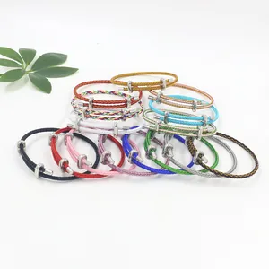 Nahaufnahme der verstellbaren Edelstahl-Hufeisenschnallen an bunten geflochtenen Armbändern