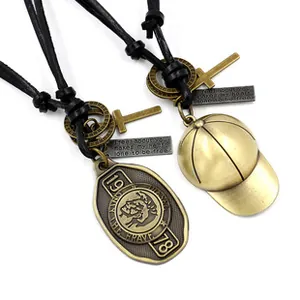 Detail of vintage bronze punk pendants with Mohawk emblem and baseball cap on leather cord