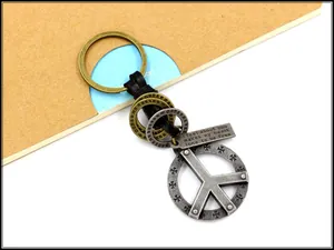 Macro detail of vintage peace sign pendant with braided leather on a keychain