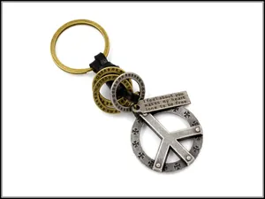 Detail of vintage peace sign pendant and leather weave keychain with engraved plaque