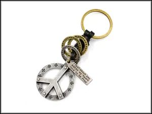 Macro view of vintage peace sign pendant with engraved metal tag on leather keychain
