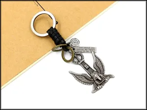 Close-up of vintage eagle pendant keychain with braided leather and engraved metal charms