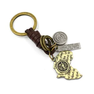 Vintage leather keychain with Australia map pendant and engraved metallic charms on white background
