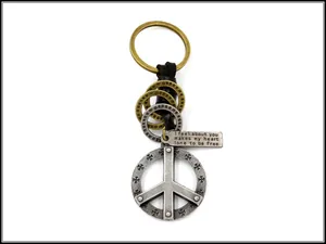 Detailed close-up of retro leather keychain with peace sign and cross metal charms