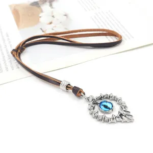 Detail of vintage silver ring pendant with blue dragon eye stone and leather cord