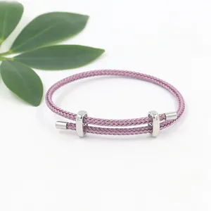 Detail eines lila geflochtenen Seilarmbands mit verstellbaren silbernen Stahlschiebern