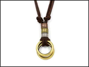 Detail of vintage bronze double-ring pendant with braided leather rope and metal beads
