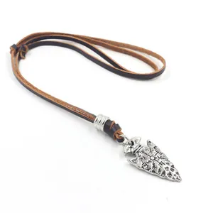 Gros plan du pendentif pointe de flèche viking avec runes sur cordon en cuir marron