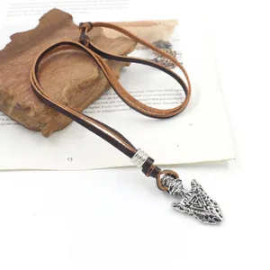 Dettaglio del ciondolo a freccia argento vintage con simbolo Valknut su cavo cuoio
