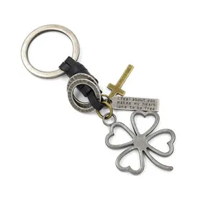 Detail of vintage bronze owl keychain with leather cord, cross and clover pendants