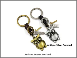 Dettaglio dei portachiavi a forma di gufo in bronzo e argento con pelle e croce