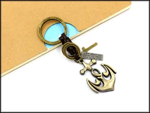 Detail of vintage anchor keychain with brown braided leather and engraved metal plaque