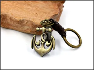 Macro view of bronze anchor keychain with leather wrap and engraved quote tag
