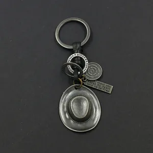 Detailed view of antique silver owl keychain with cowboy hat and engraved quote tag