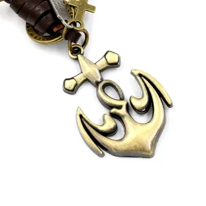 Vintage bronze anchor cross pendant with brown layered leather cord on white background