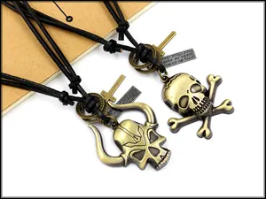 Detail of punk leather necklaces featuring bronze skull pendants and adjustable cords