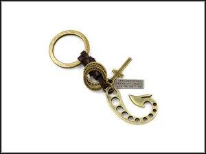 Detail of bronze fishhook keychain with braided leather, cross charm and engraved plate
