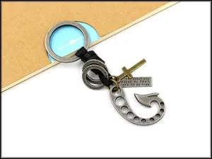 Detailed view of vintage fishhook keychain with leather strap and engraved cross charm