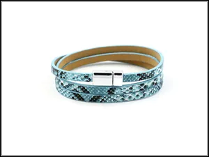 Detail van meerlaagse leren armband met blauw slangenpatroon en magnetische sluiting