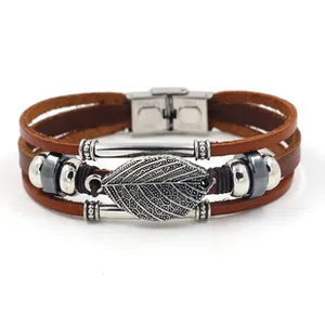 Close-up of vintage multi-layer leather bracelet with silver leaf pendant and metal beads