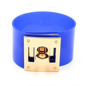 Detail of blue wide cuff bracelet featuring gold buckle and rivet hardware