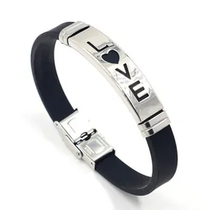 Detalle de placa LOVE de acero inoxidable en una pulsera unisex de cuero negro y silicona