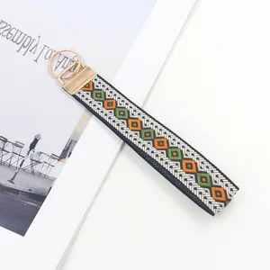 Detail eines gewebten Schlüsselbandes im Boho-Stil mit goldenem Verschluss und Schlüsselring