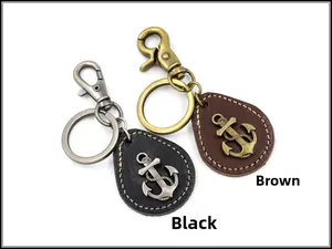 Dettaglio di portachiavi in pelle con ancora in nero e marrone e ciondoli vintage