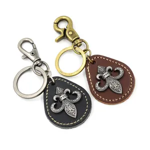 Detailed view of vintage leather keychains with fleur-de-lis metal embossed ornaments