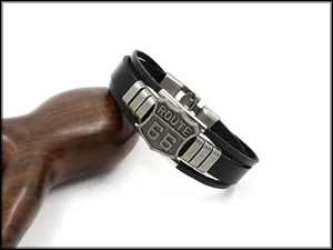 Detail of vintage double-layer black leather bracelet with antique silver Route 66 shield