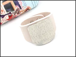 Detail of light pink lychee texture leather bracelet with textured silver metal square