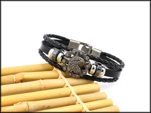Macro shot of a men's woven leather bracelet featuring an eagle emblem and metallic beads