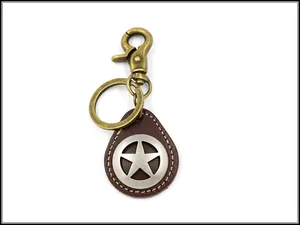 Detalle de llavero de cuero vintage con gancho de bronce y colgante de estrella