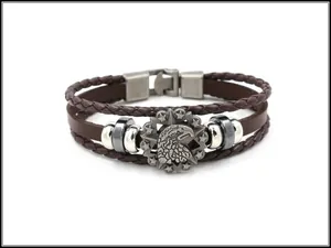 Close-up of men's leather bracelet with eagle head emblem and star metal charms