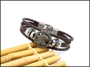 Detail of men's multi-layer brown leather bracelet with eagle and star metal emblem