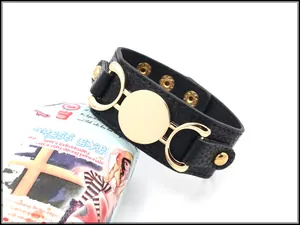 Detail of black pebbled PU leather wide cuff bracelet with adjustable gold snap buttons