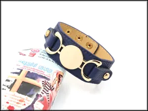 Detail of navy blue pebble leather cuff bracelet with gold buckles and adjustable snap buttons