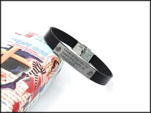 Detail eines Lederarmbands mit einer gravierten Edelstahlplatte und Zitat-Gravur