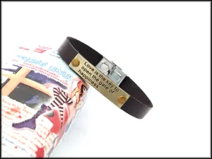 Makro-Detail des braunen Lederarmbands mit gravierter Motivations-Metallplatte