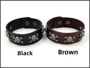 Detail van de zwarte en bruine punkleren armbanden met metalen schedel- en botten-studs