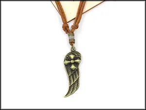 Dettaglio pendente con ala e croce in bronzo con cordino in pelle intrecciata su legno