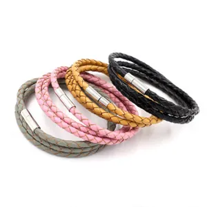 Dettaglio di bracciali multistrato in pelle intrecciata con chiusure magnetiche argento