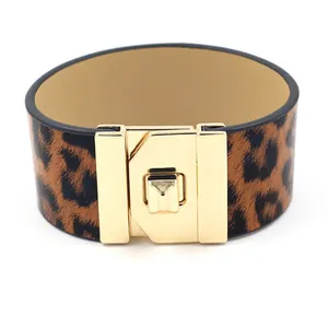 Close-up of leopard print leather bracelet featuring a polished gold metal clasp detail