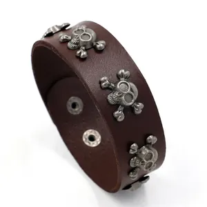 Punk style wide leather wristband with silver skull studs and adjustable snap closure