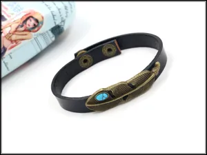 Detail von Bronze-Federanhänger und blauem Türkis auf schwarzem Lederarmband für Damen
