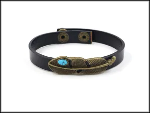 Detailansicht des Lederarmbands mit bronzenem Federanhänger und Türkis-Inlay